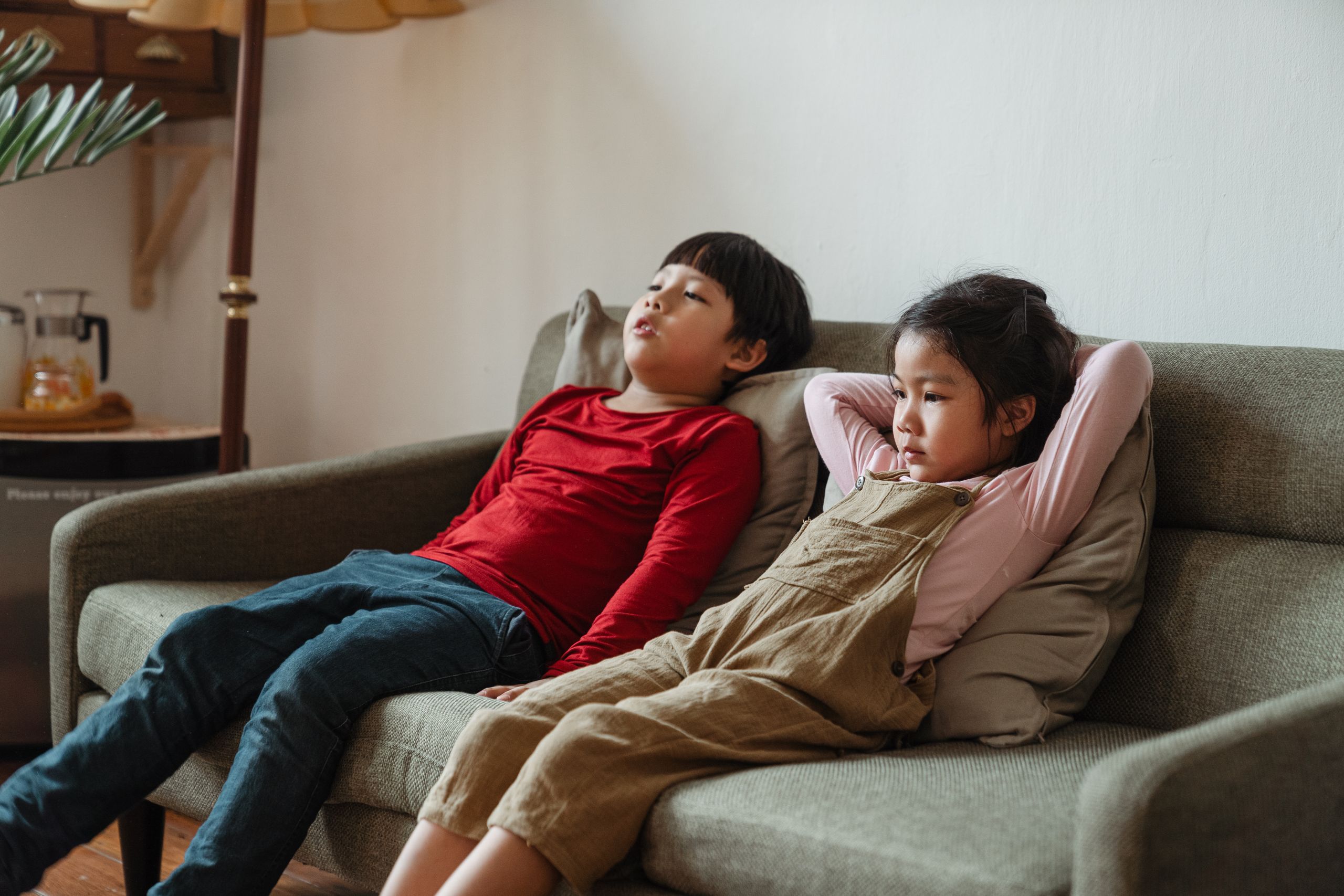 Children enjoying a relaxing moment on a sofa, embodying leisure and comfort indoors.